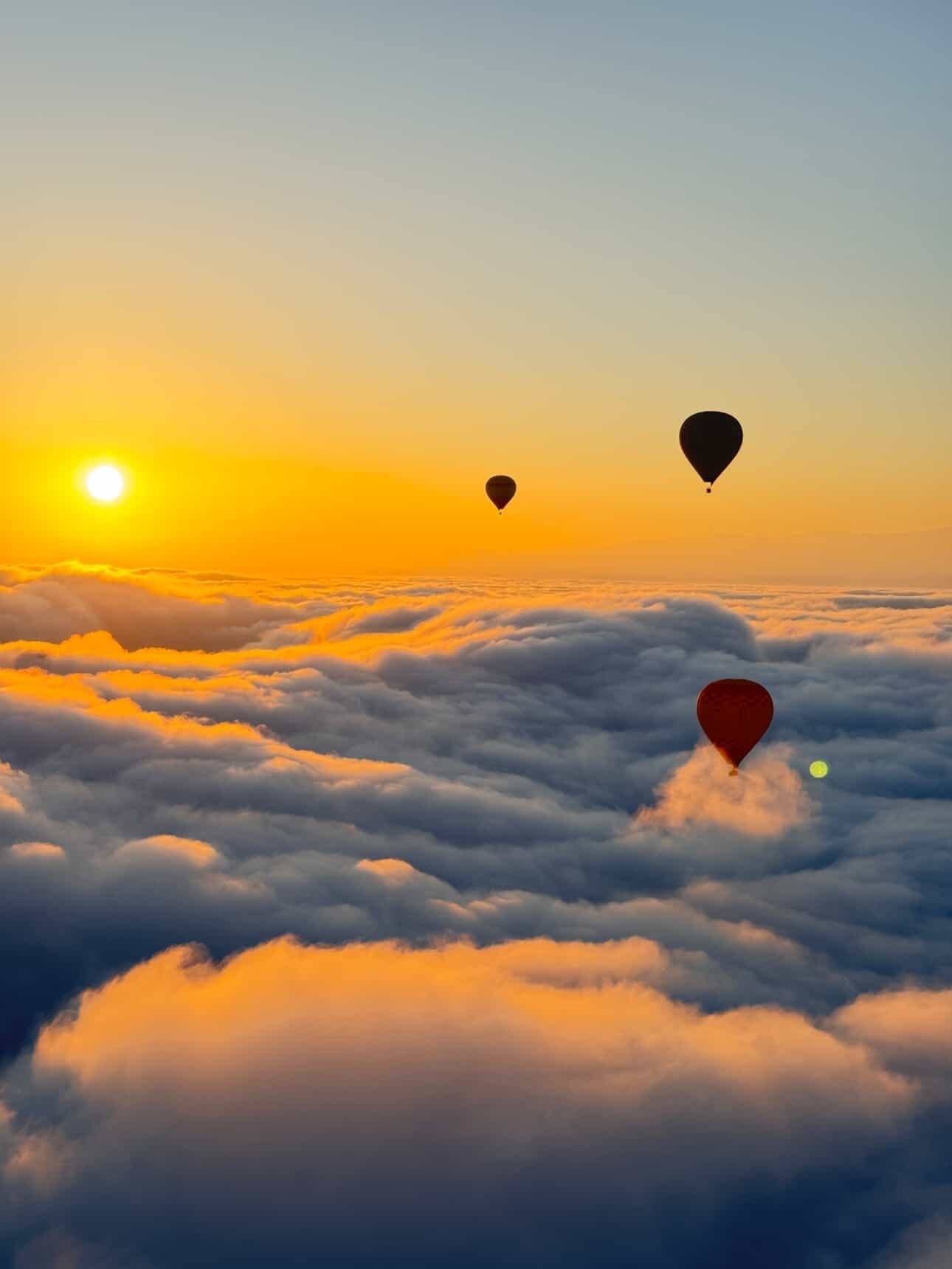 Hot air balloons above a sea of clouds at sunrise near Marrakech