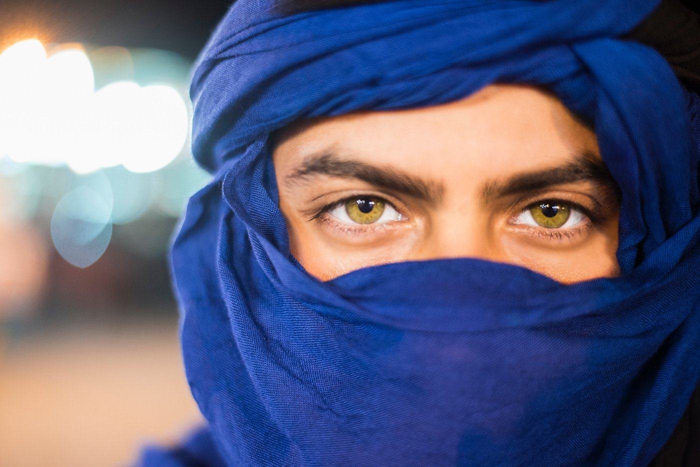 A man in a blue turban in the Moroccan desert