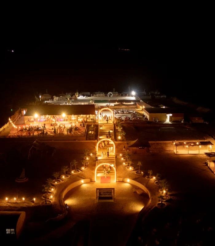 A luxury desert camp lit at night, seen from above