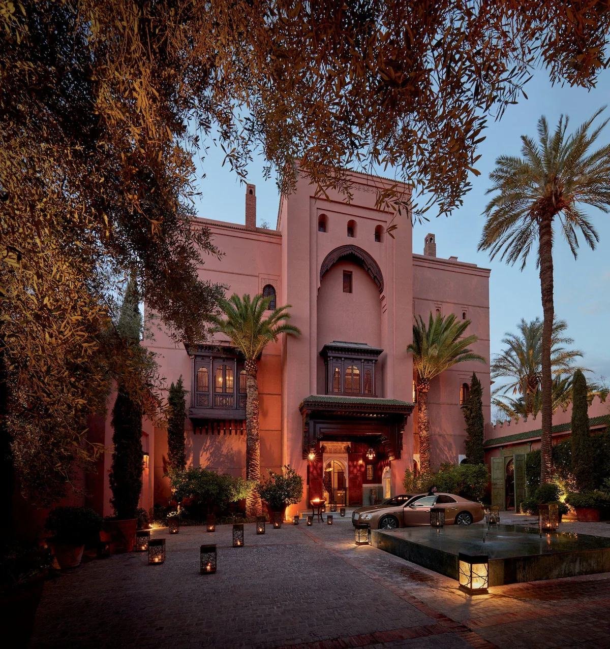 Entrance of a palace hotel in Marrakech lit by lanterns at dusk
