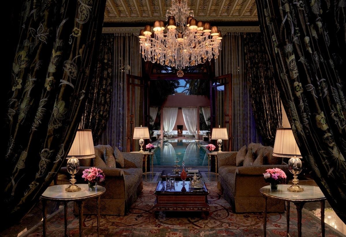Private salon with chandelier opening onto a pool in a luxury riad in Marrakech